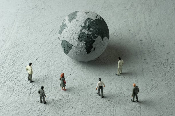 Businessman/Politician figurines examine a concrete globe (Europe, Africa)